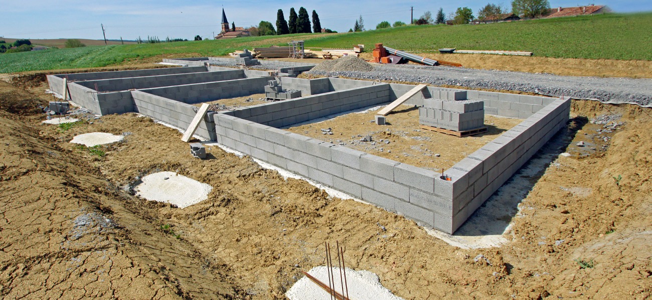 Drainage d'une maison : tranchée le long des fondations sur un chantier