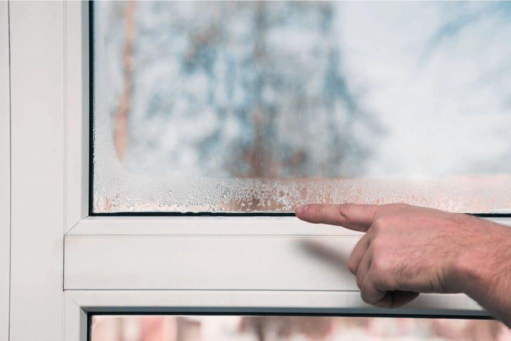 doigt homme montrant le rebord de la fenêtre pleine de buée et humidité maison problème