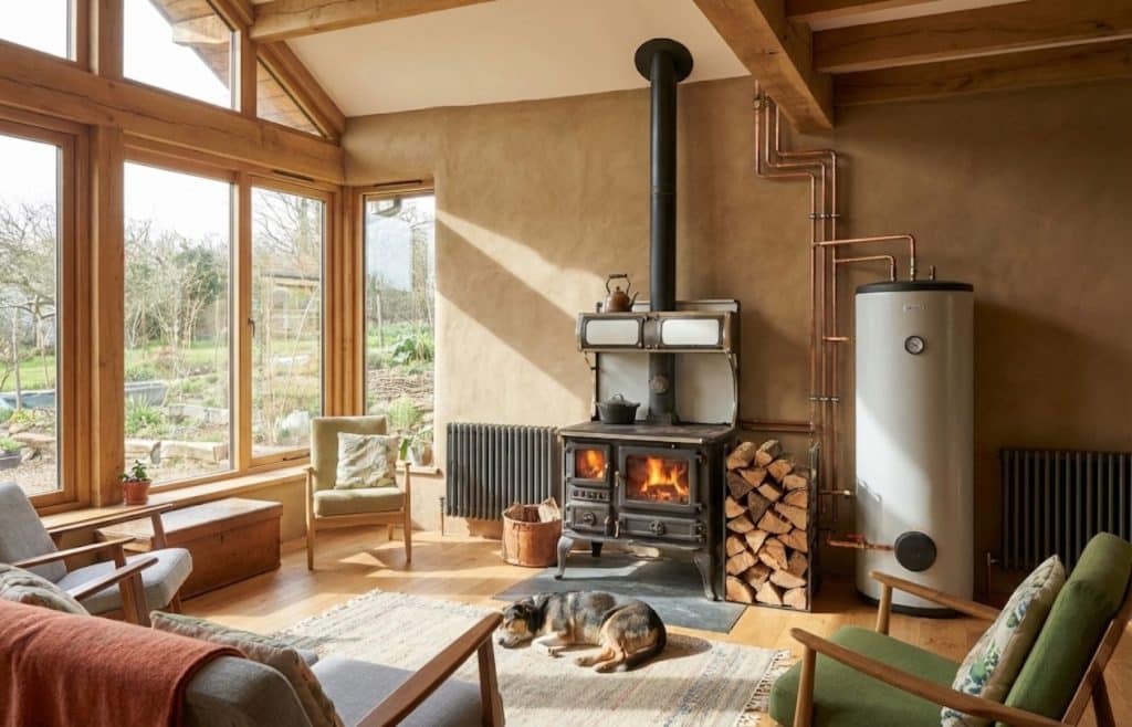 Ancienne cuisinière à bois récupérée et transformée en système de chauffage central dans un salon de maison bioclimatique salon chien