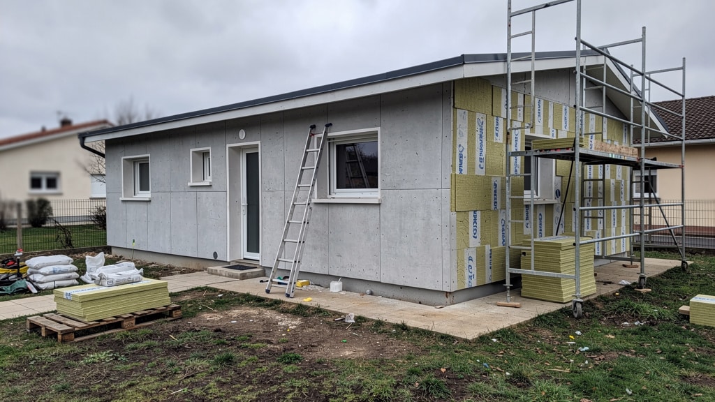 Maison Phénix des années 70 en cours d'isolation par l'extérieur, échafaudage et panneaux isolants