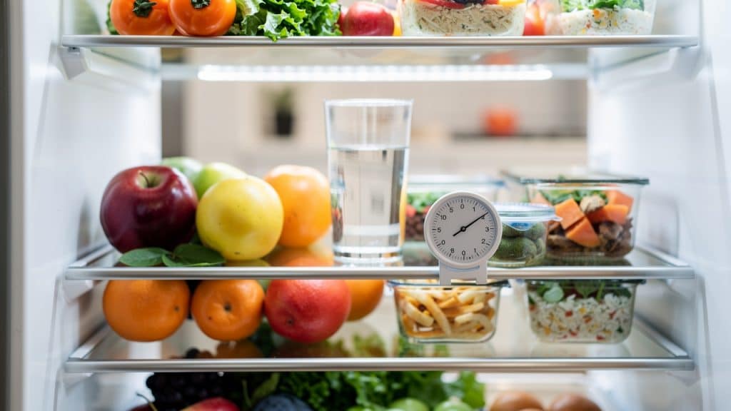 Température frigo : verre d'eau et thermomètre posés sur la clayette centrale d'un réfrigérateur